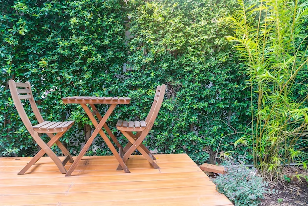 Terrasse rangée bois table et chaises bois arbustes