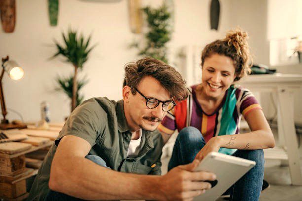 Couple plannification vacances regard sur la tablette devis voyages